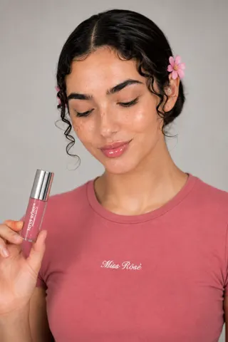 Model with lip gloss and pink tee