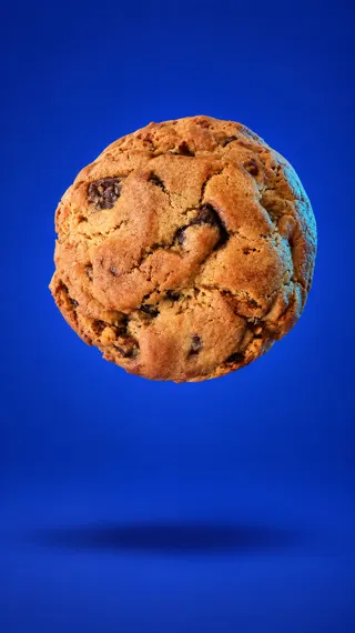 Floating chocolate-chip cookie on blue